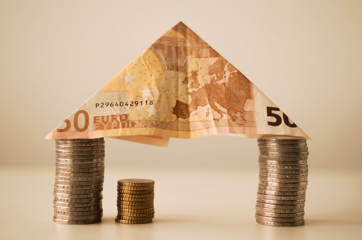 50 euro banknote folding on top of piled coins