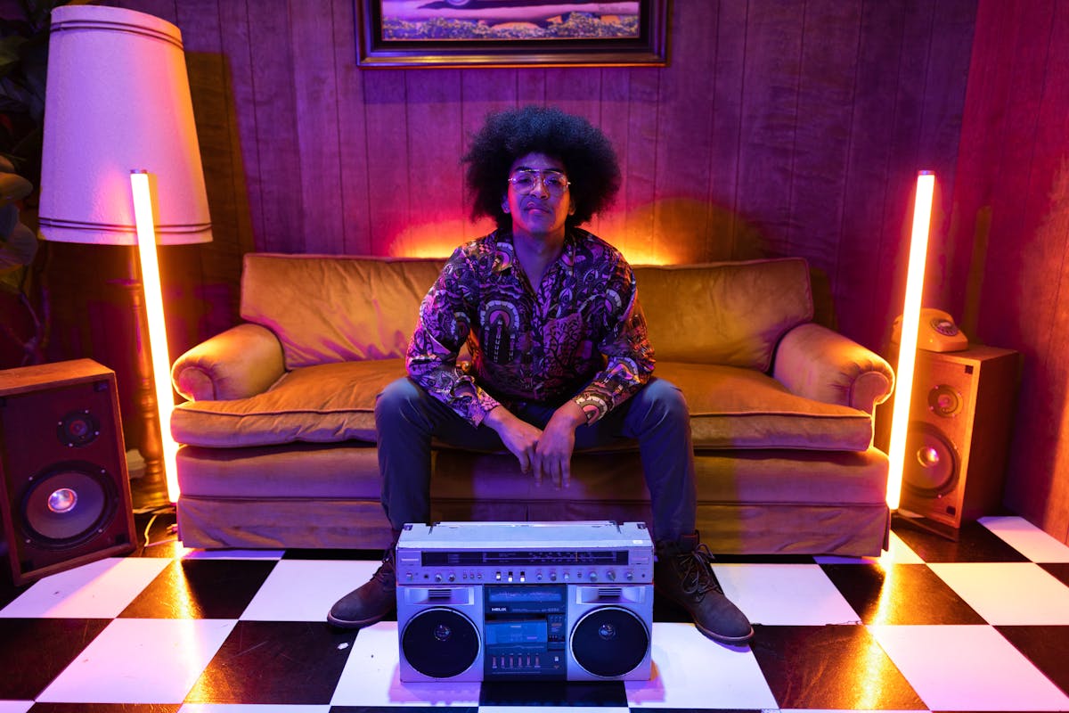 a boombox in front of a man sitting on the couch