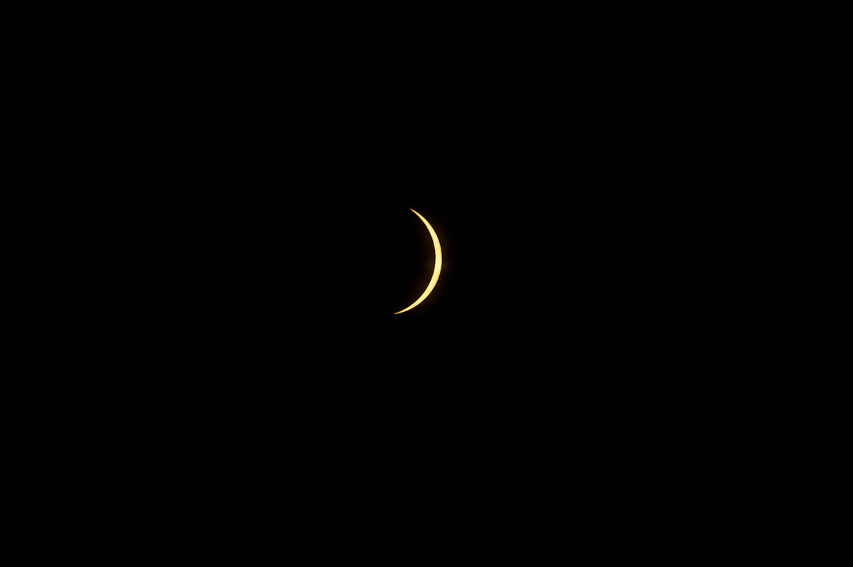 a crescent moon in the dark sky