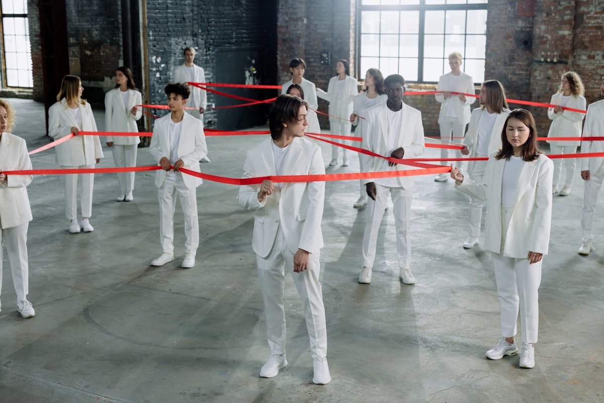 a group of people holding a red ribbon