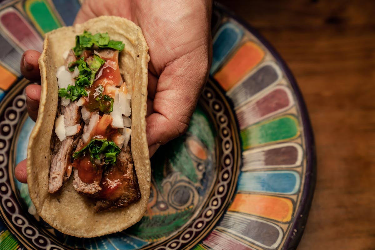 a person holding a taco