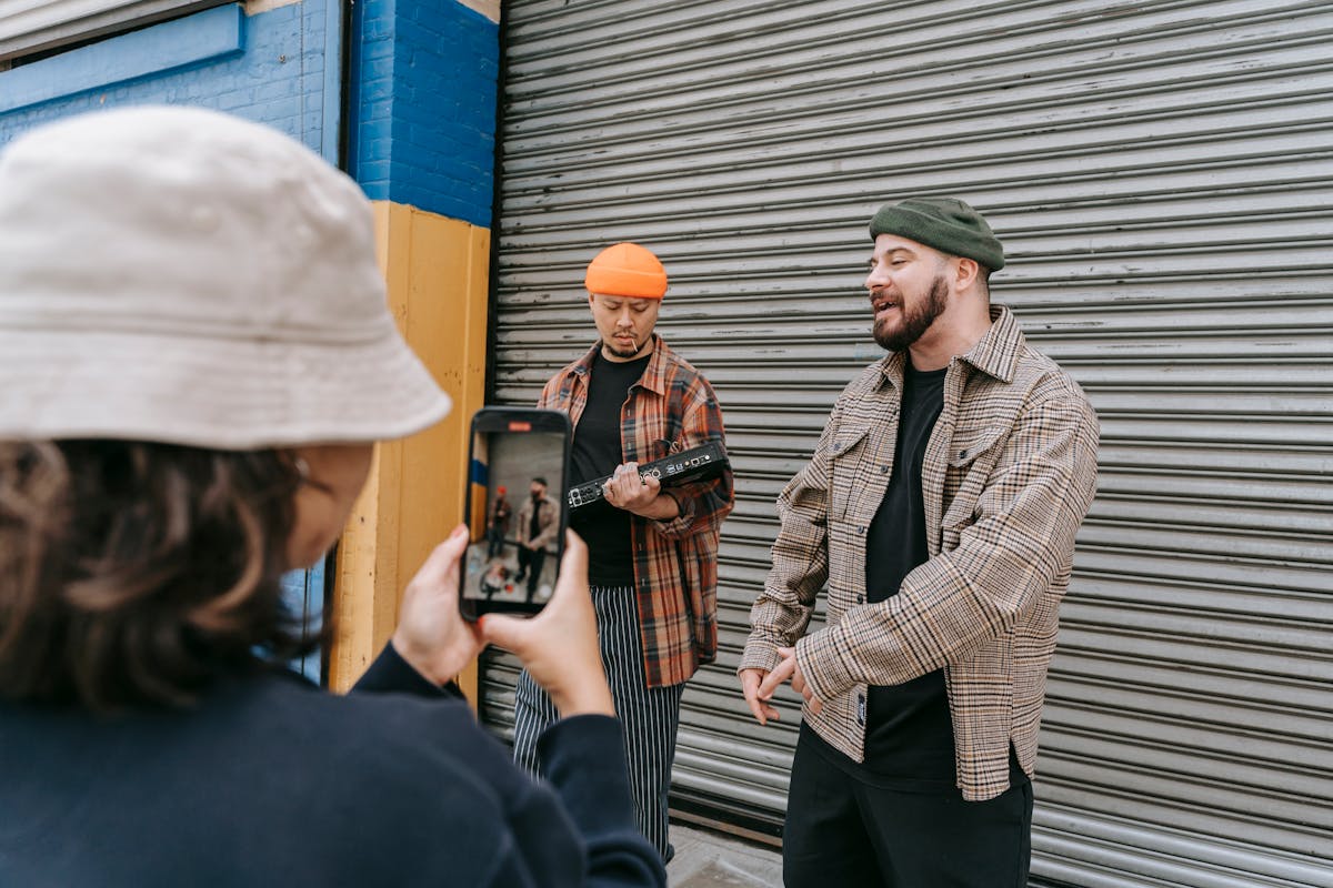 a person recording a man singing on a street