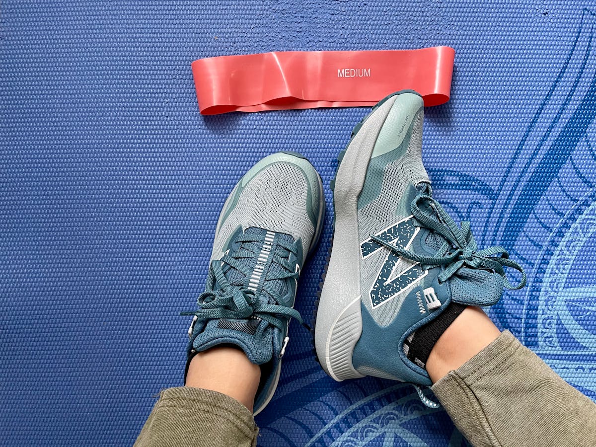 athletic shoes and resistance band on mat