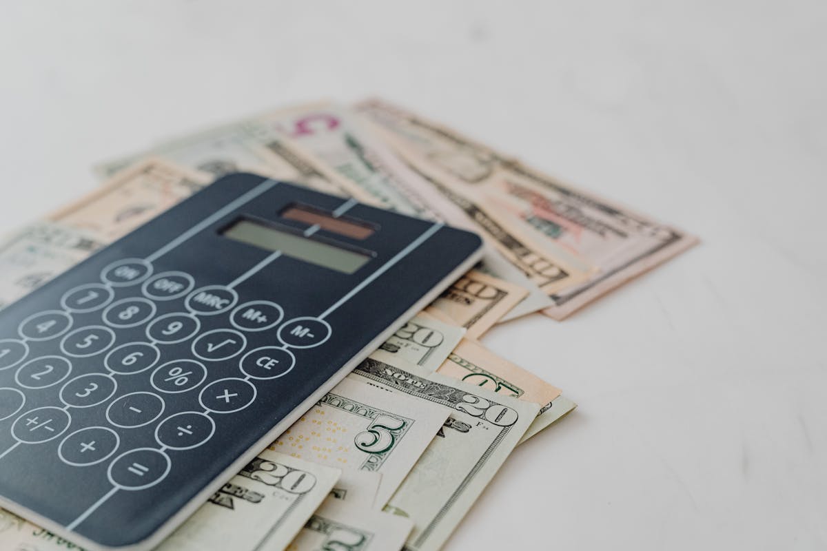 black calculator on top of banknotes