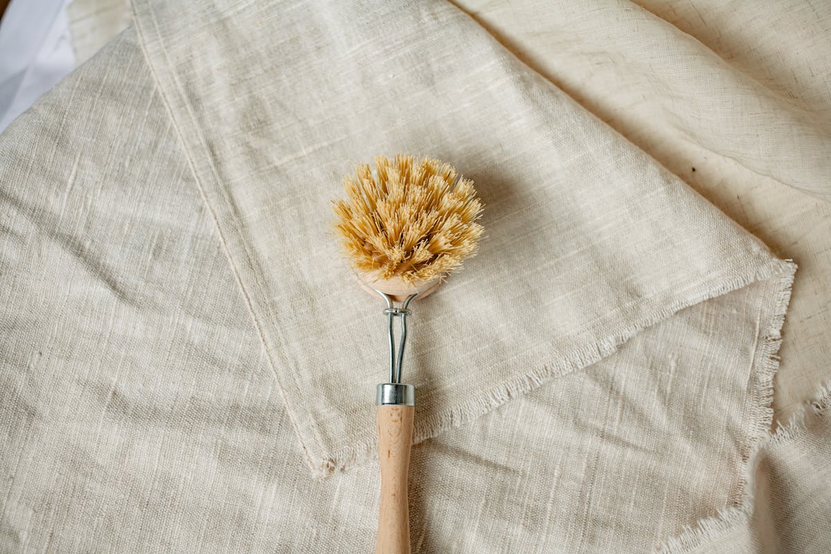 close up of a cleaning brush lying on linen fabric