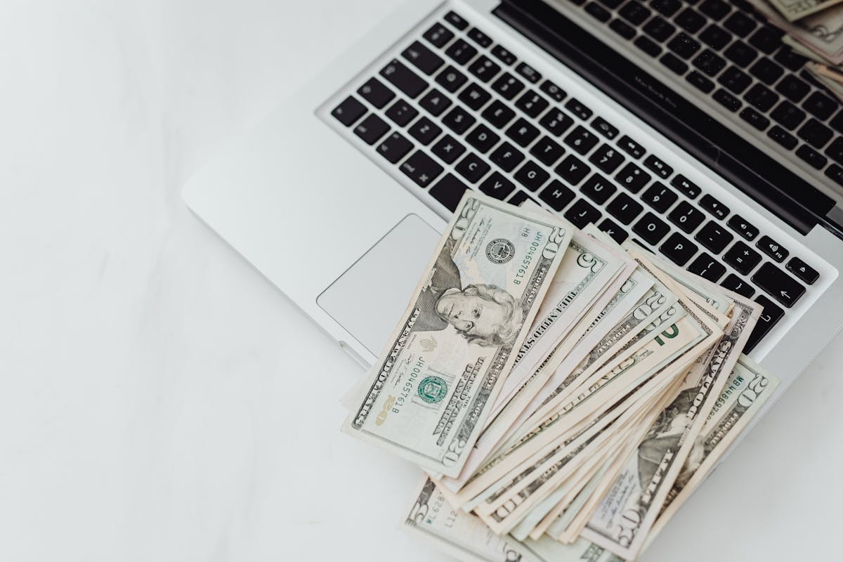 close up photo of banknotes on top of a laptop s keyboard
