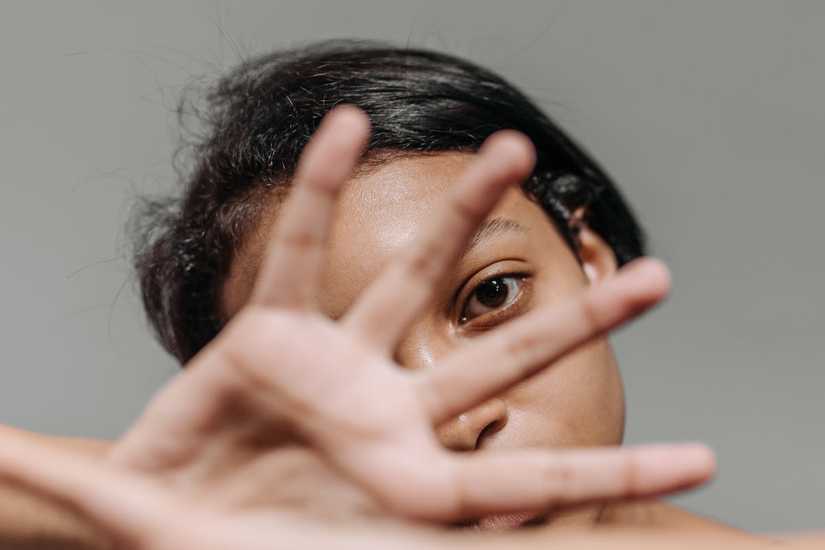 close up shot of woman covering her face with her hand