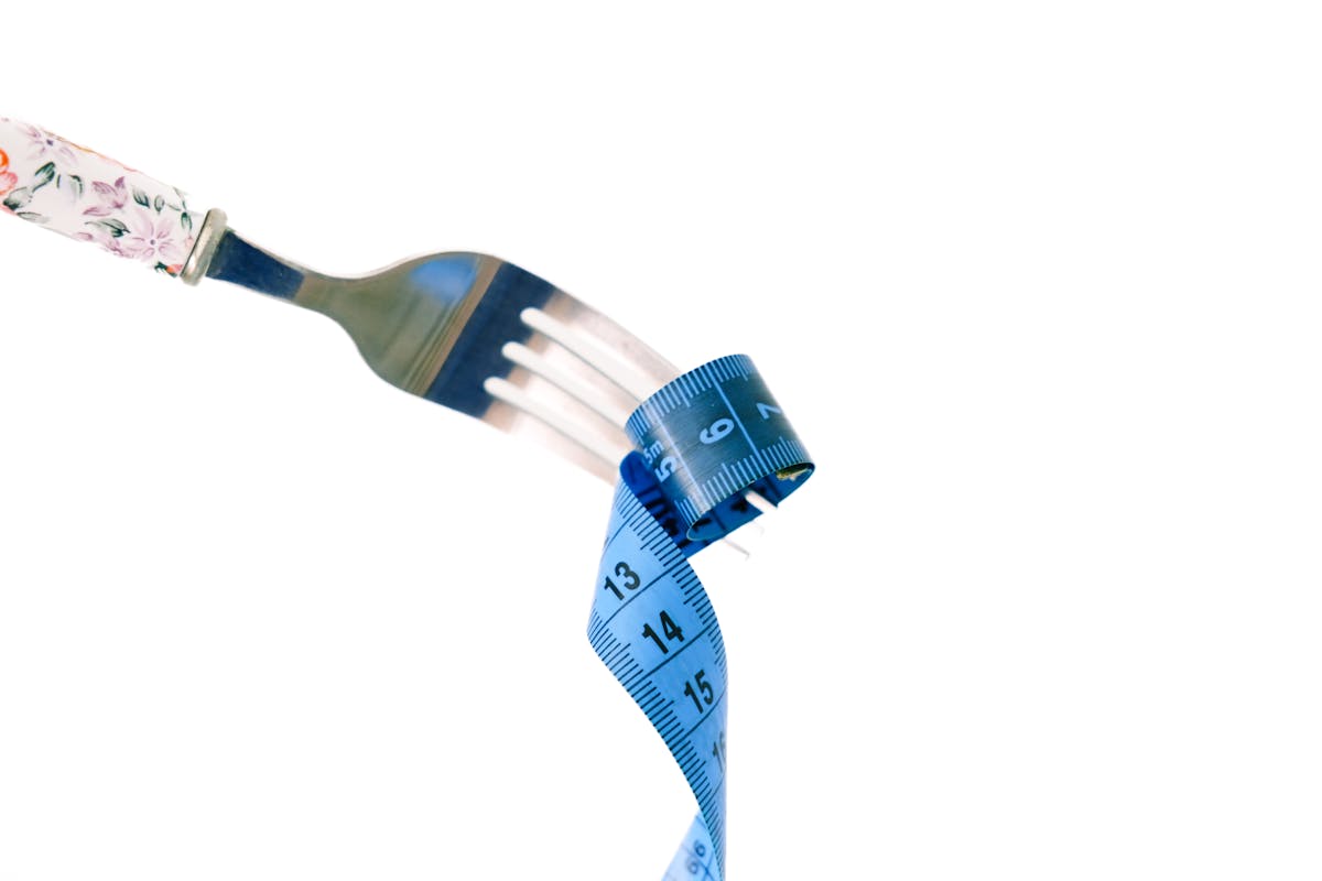 creative dieting concept with fork and tape measure