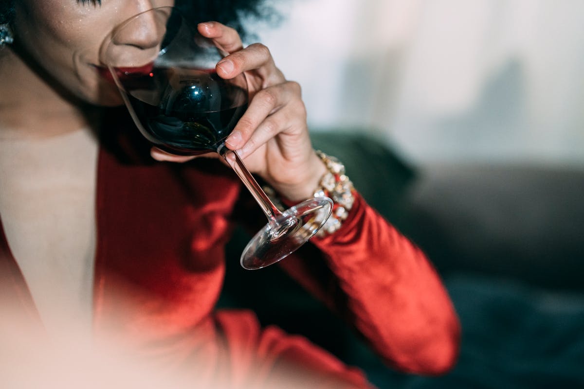 crop woman drinking red wine