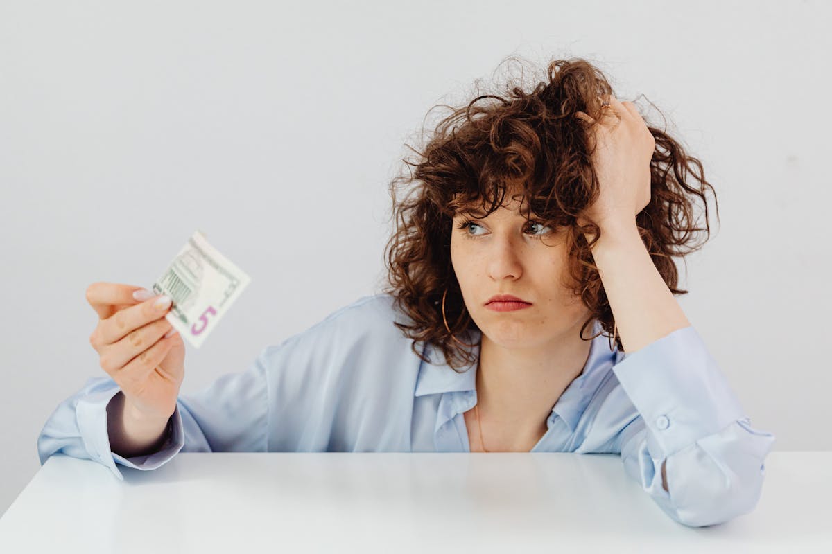 curly haired woman holding a paper money