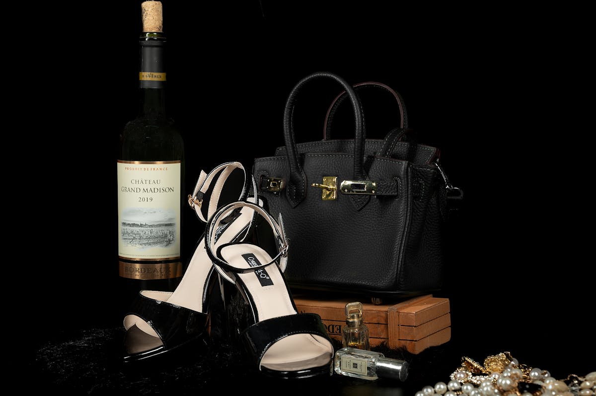 elegant black accessories with wine and perfume
