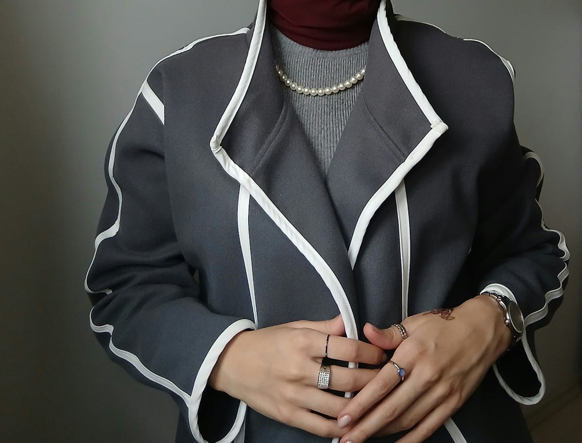 fashionable woman in grey coat with jewelry