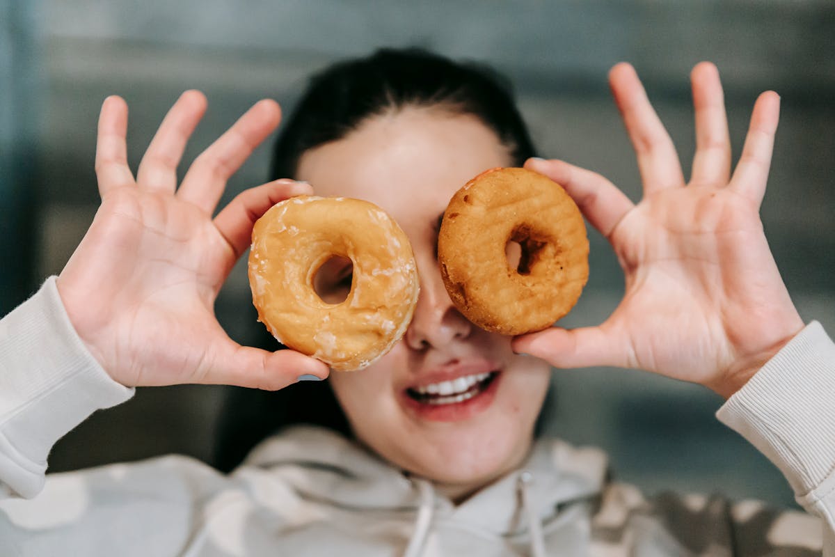 funny woman holding donuts before eyes