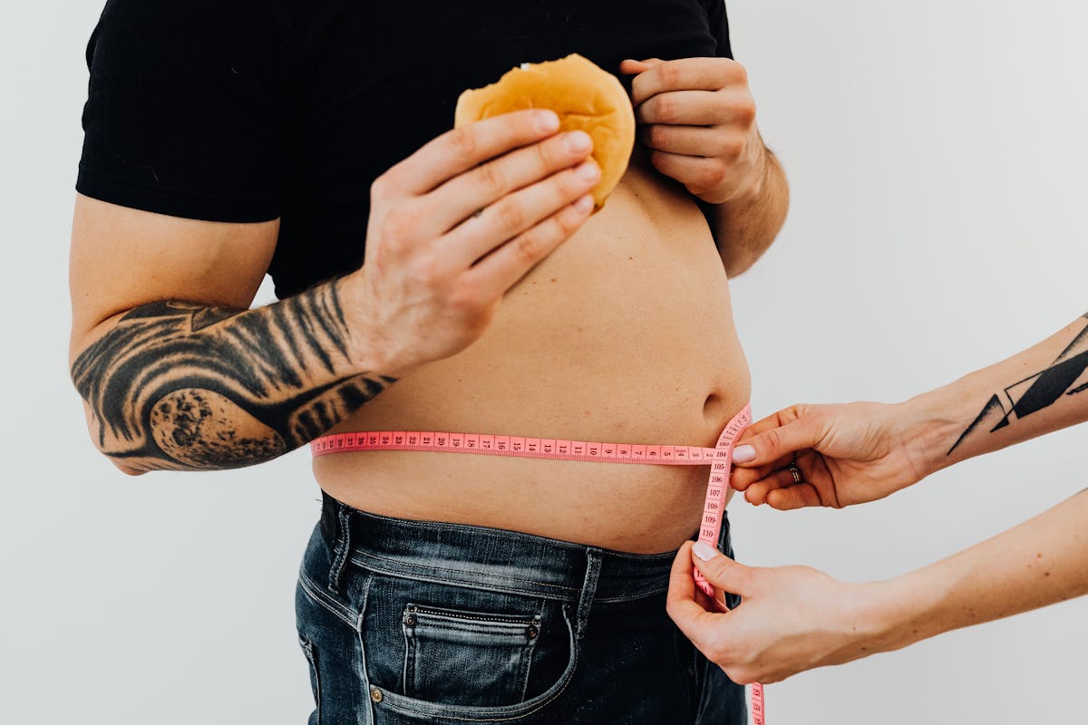 hands of a person measuring a man s waistline