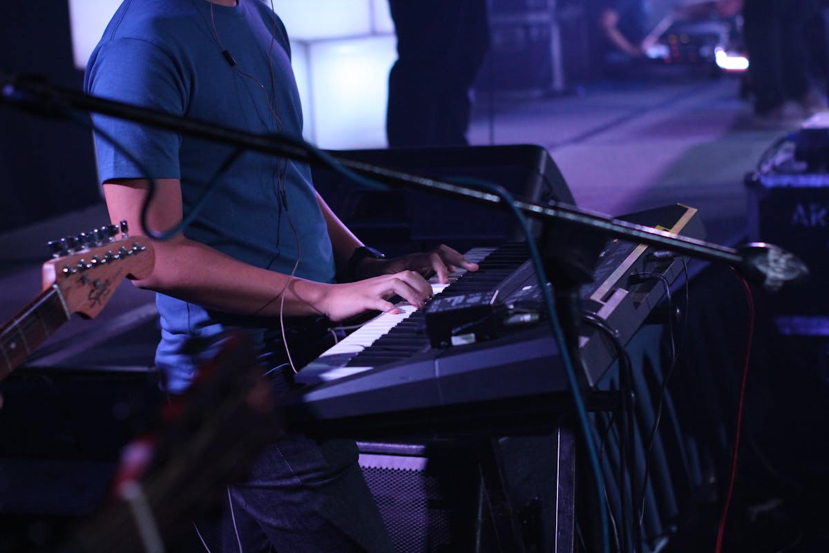 man standing while playing keyboard
