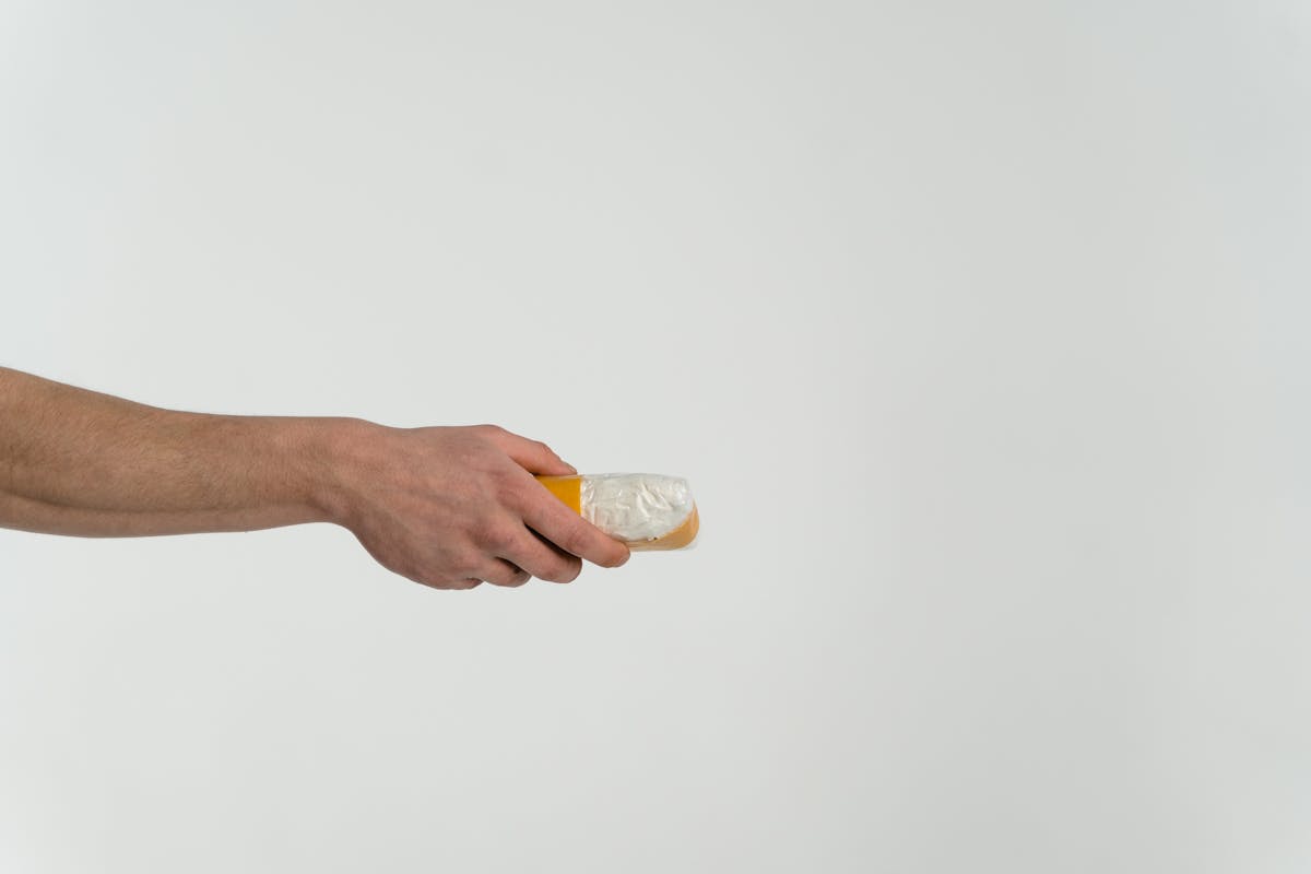 person holding clear glass bottle