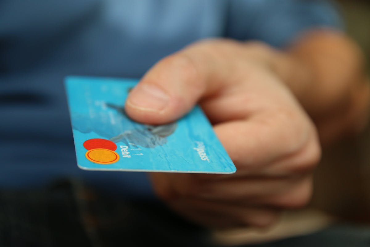 person holding debit card person holding debit card