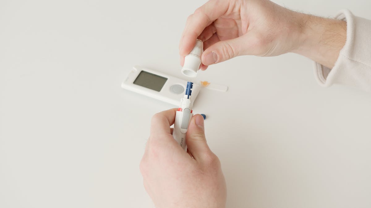 person holding white blood sugar tester