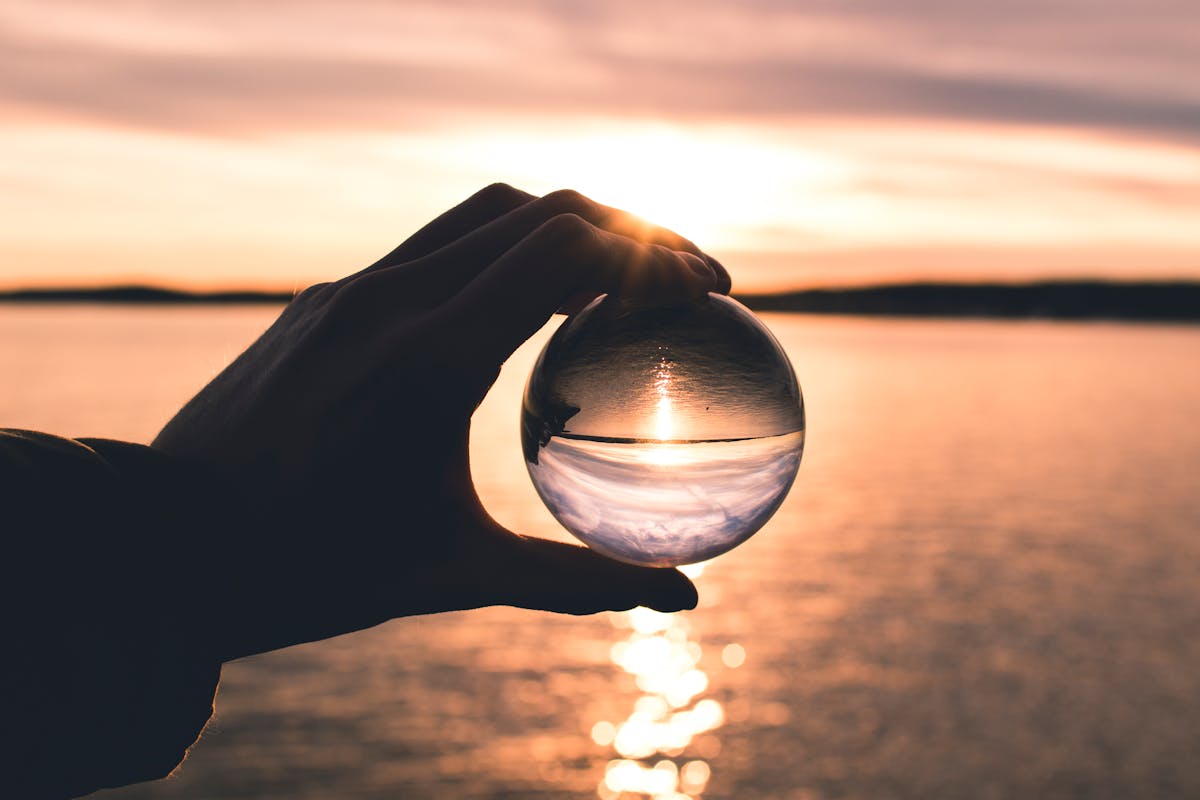 photo displays person holding ball with reflection of horizon photo displays person holding ball with reflection of horizon