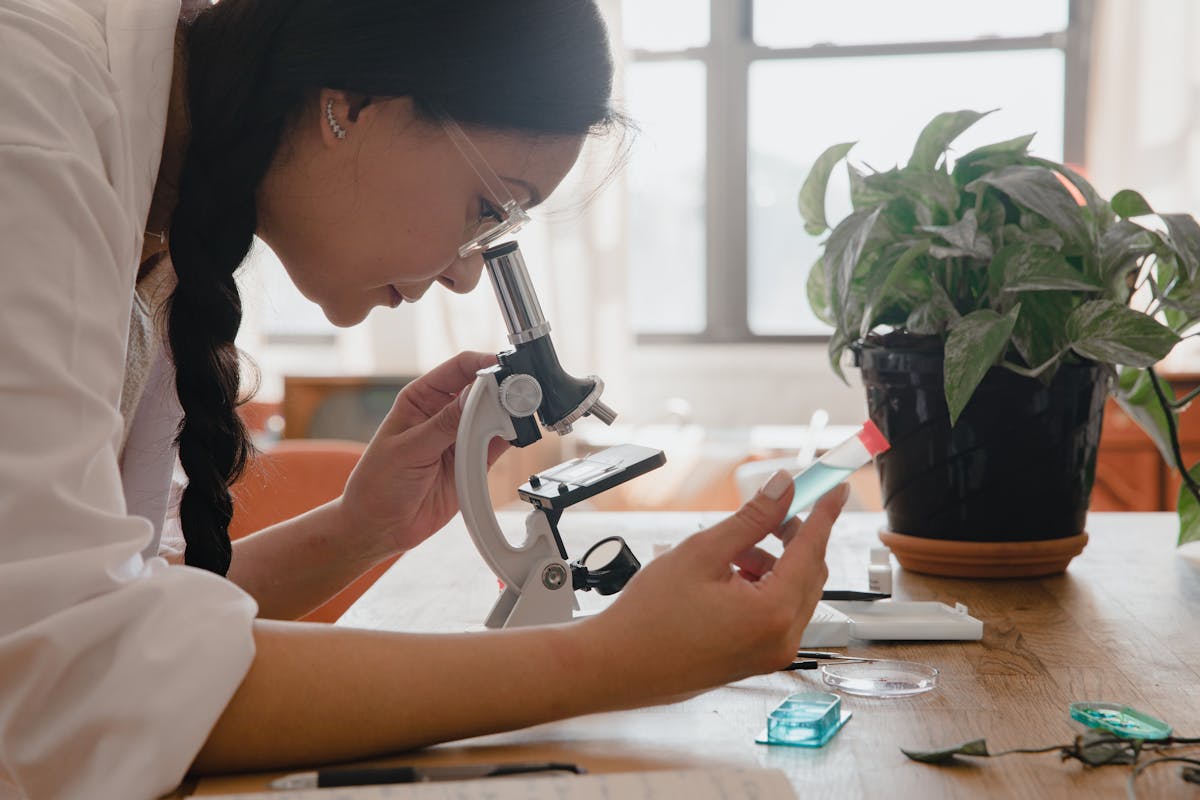 side view of a woman using a microscope