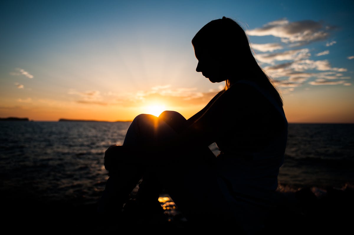 silhouette of person sitting outdoors