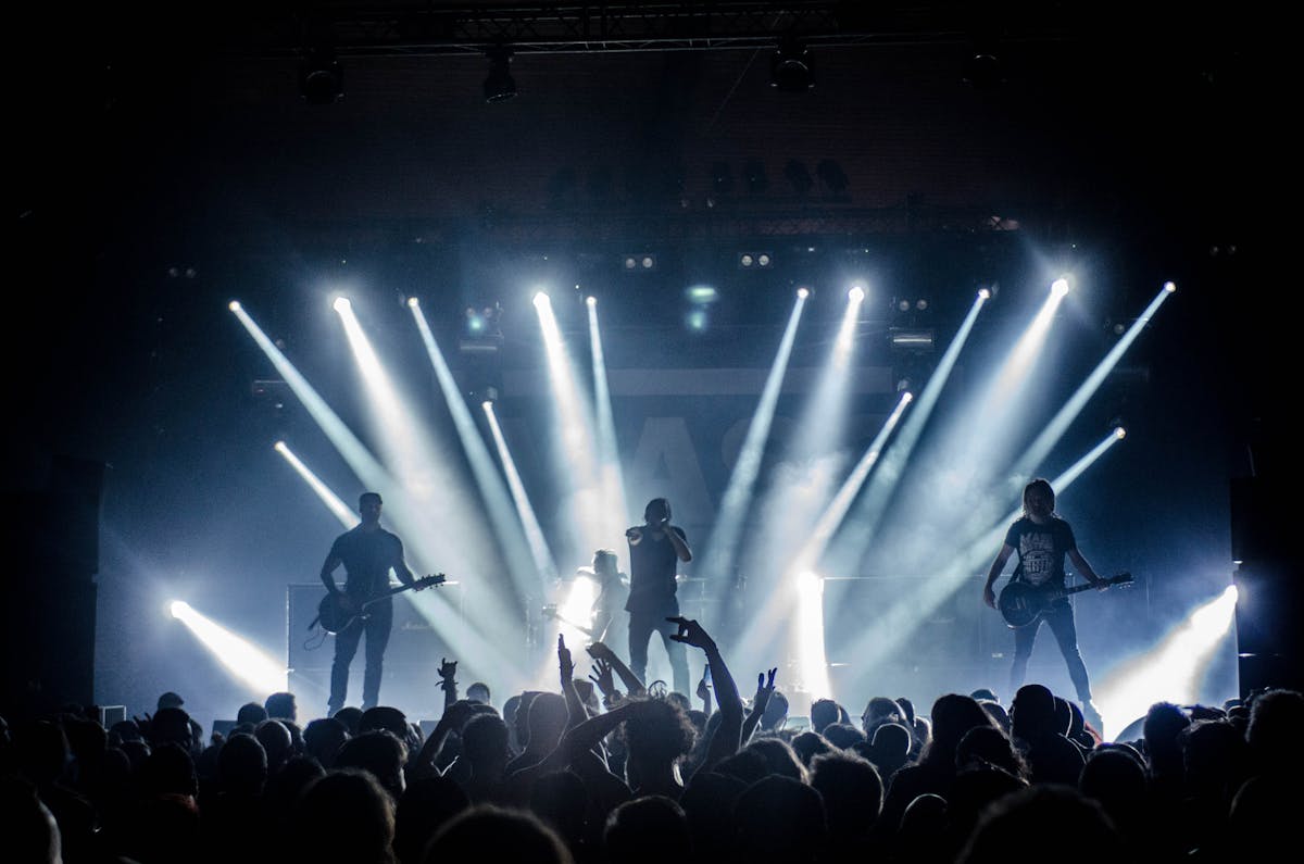 singer singing on stage beside guitar player and bass player singer singing on stage beside guitar player and bass player