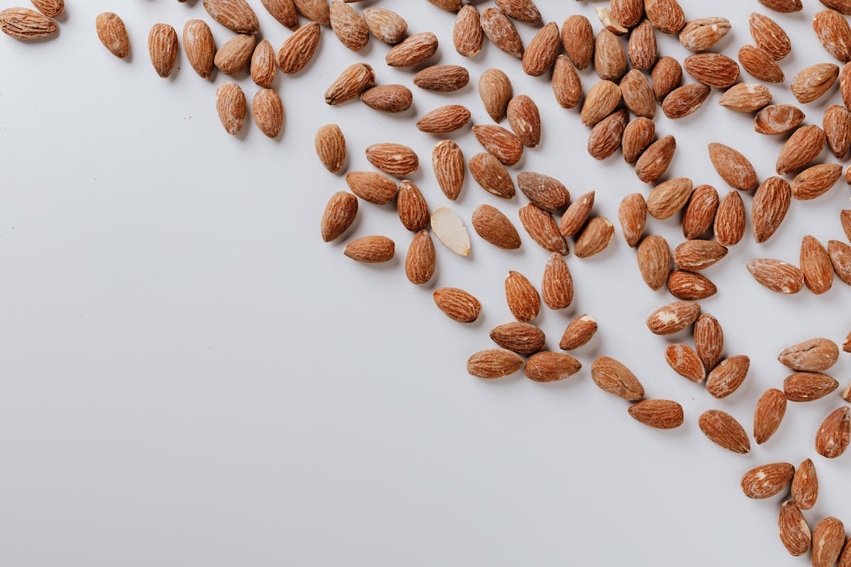 white table with tasty scattered almonds white table with tasty scattered almonds