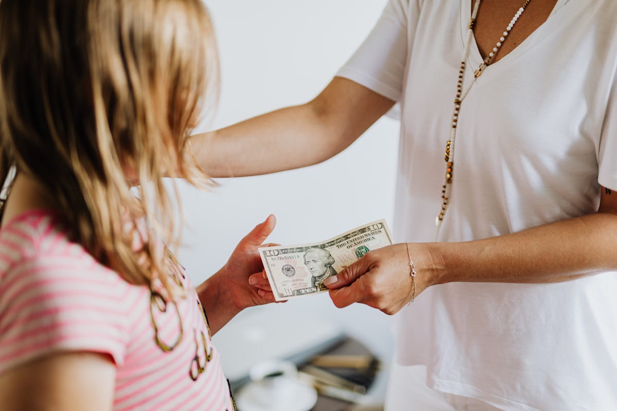 woman giving 10 dollars to a girl