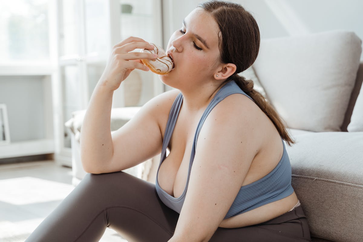 woman in blue sports bra eating donut