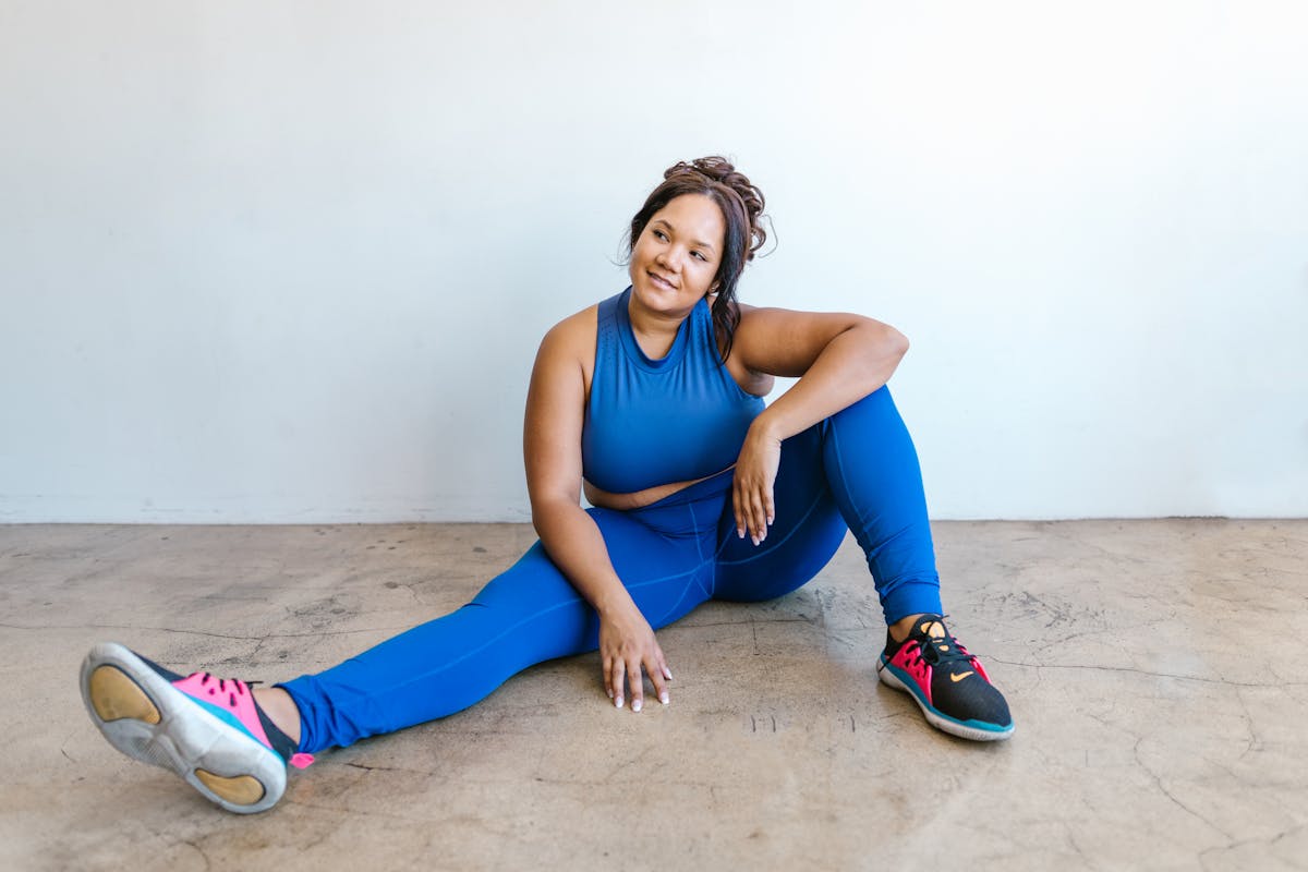 woman in blue tank top and blue pants sitting on floor
