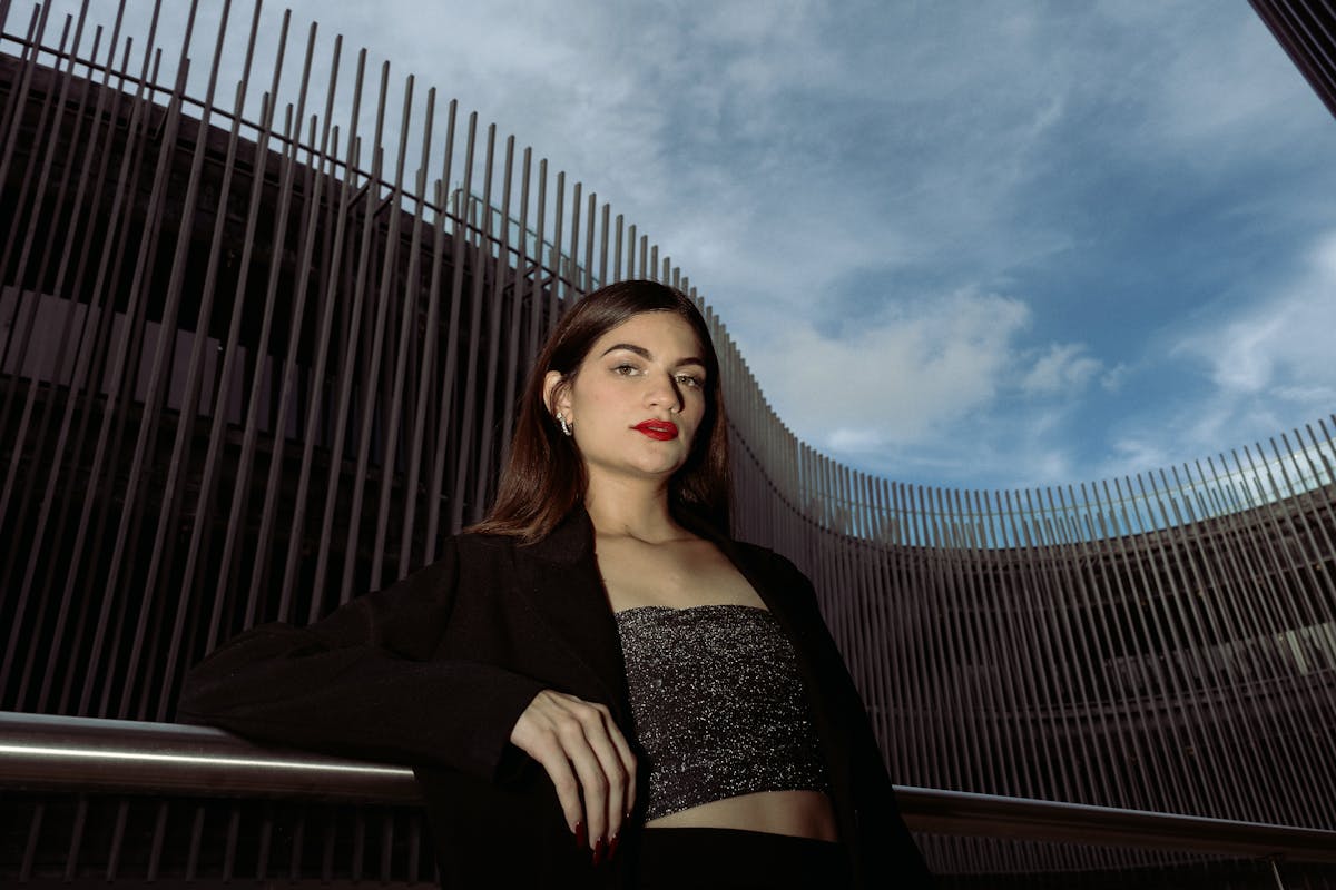 woman posing in black blazer and sparkle bandeau top