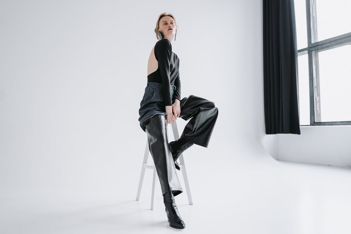 woman posing while sitting on white stool chair