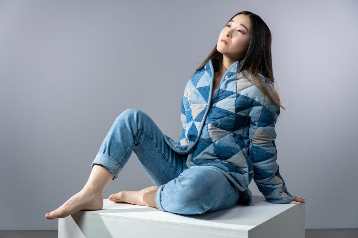 woman wearing denim clothes sitting on a box