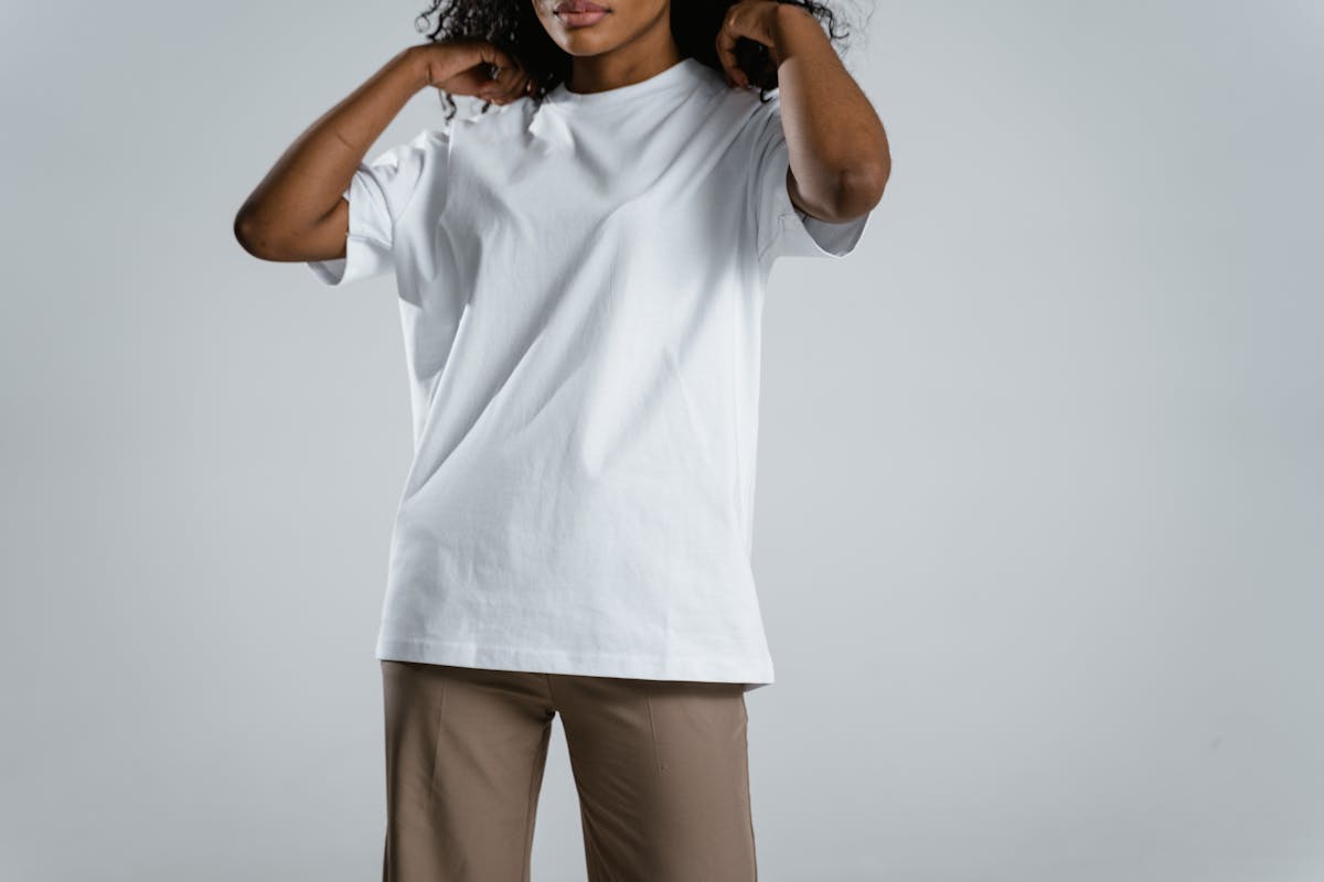 woman wearing white crew neck shirt and brown pants