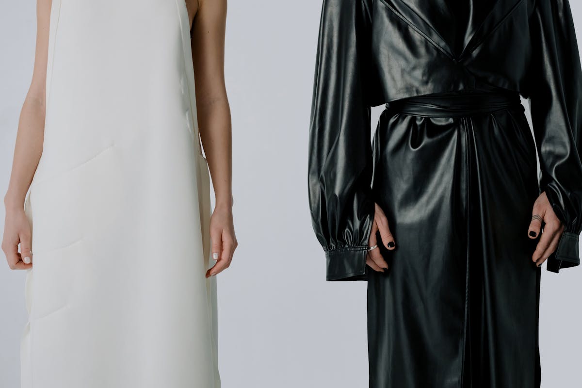 women in a white dress and a black leather trench coat