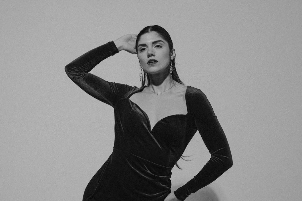 young woman in elegant dress posing in studio